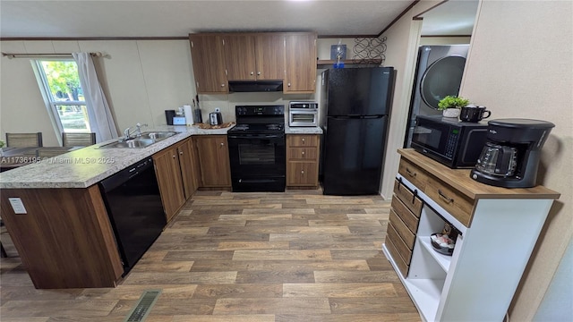 kitchen featuring sink, ornamental molding, black appliances, kitchen peninsula, and light wood-type flooring