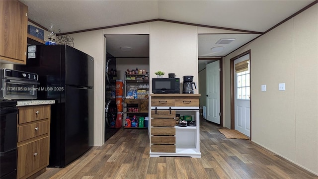 kitchen with crown molding, dark hardwood / wood-style floors, vaulted ceiling, and black appliances