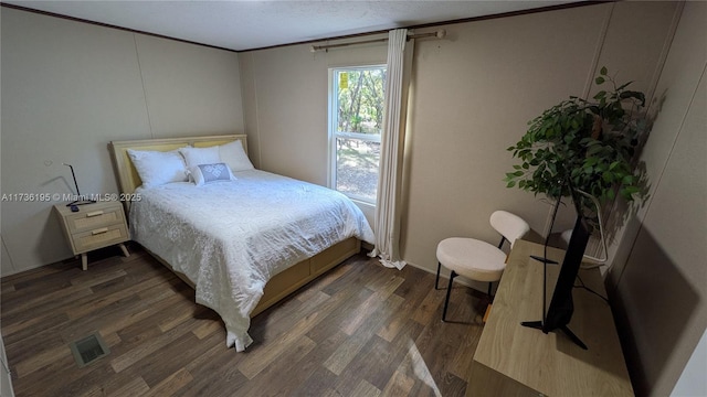 bedroom with crown molding, dark hardwood / wood-style floors, and a textured ceiling