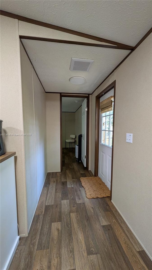 hall featuring dark wood-type flooring and a textured ceiling