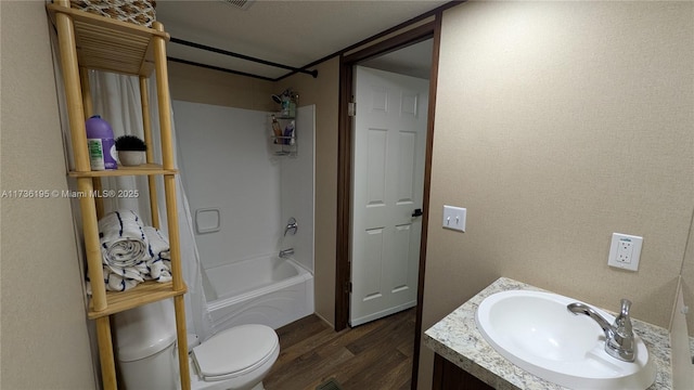 full bathroom featuring vanity, hardwood / wood-style flooring, shower / tub combination, and toilet