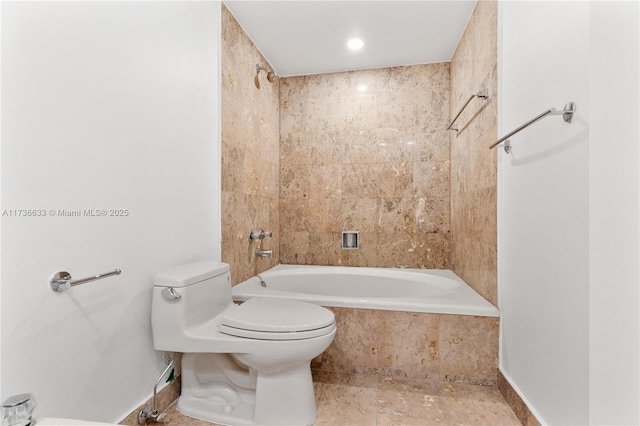 bathroom featuring tiled shower / bath and toilet