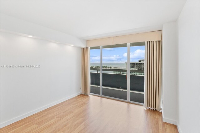 unfurnished room with hardwood / wood-style flooring