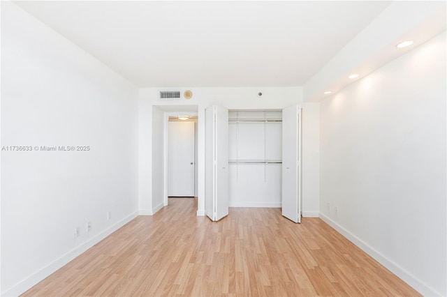 unfurnished bedroom with light wood-type flooring and a closet