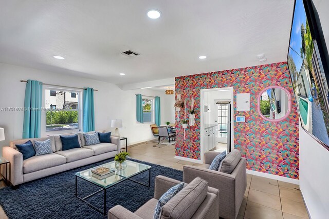 living room featuring a healthy amount of sunlight, light tile patterned floors, and a textured ceiling