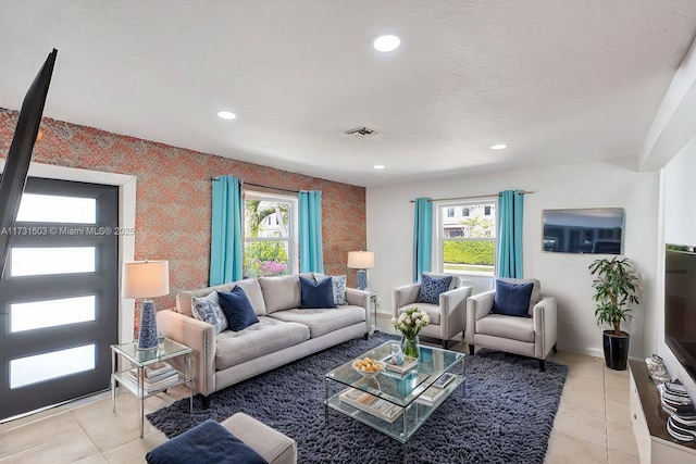 living area featuring visible vents, plenty of natural light, and light tile patterned floors