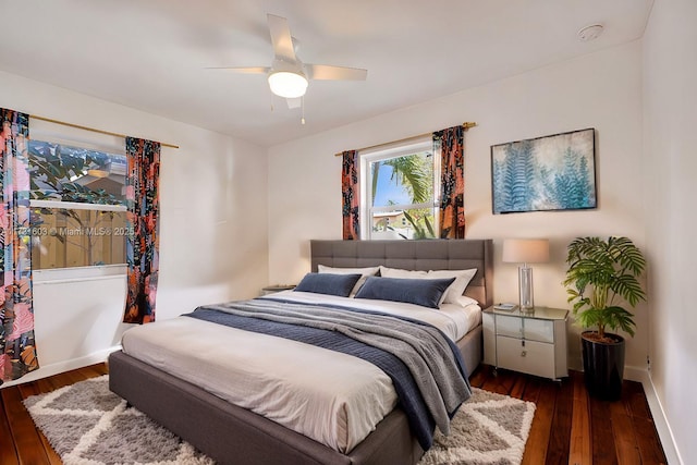 bedroom with dark wood-style floors, a ceiling fan, and baseboards