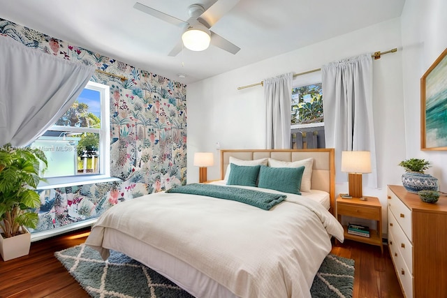 bedroom with ceiling fan, multiple windows, and wood finished floors