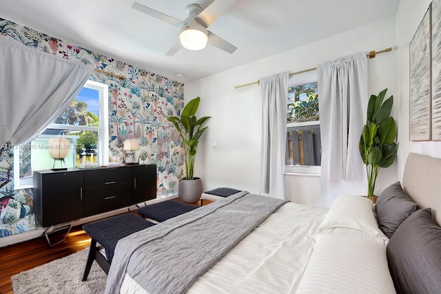 bedroom with a ceiling fan, multiple windows, and wood finished floors