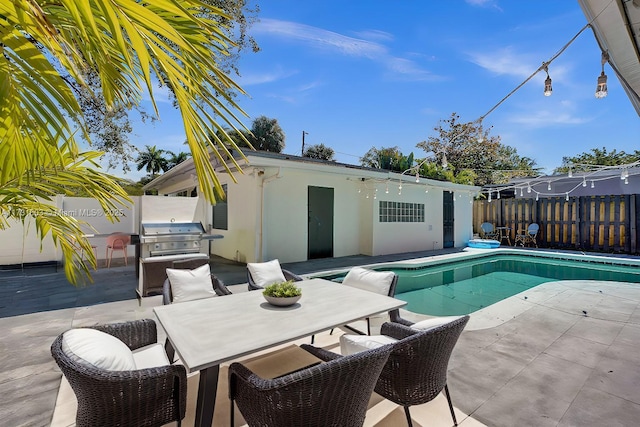 view of pool featuring grilling area and a patio area