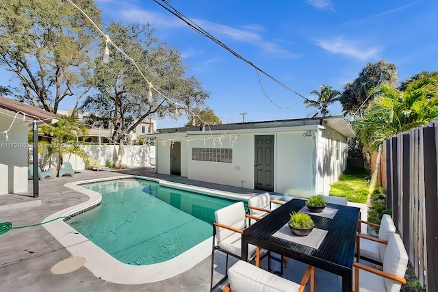 view of pool with a patio area, a fenced backyard, an outdoor structure, and a fenced in pool