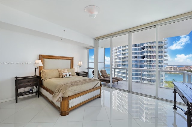 bedroom with a water view, expansive windows, light tile patterned flooring, and access to outside