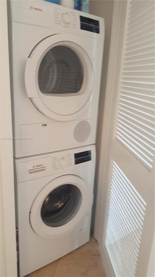 washroom with stacked washer / drying machine, laundry area, and light tile patterned floors
