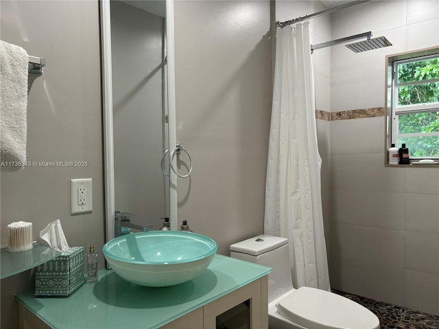 bathroom with walk in shower, vanity, and toilet