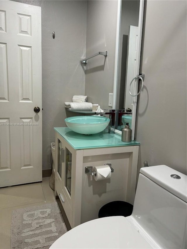 bathroom featuring vanity, toilet, and tile patterned flooring