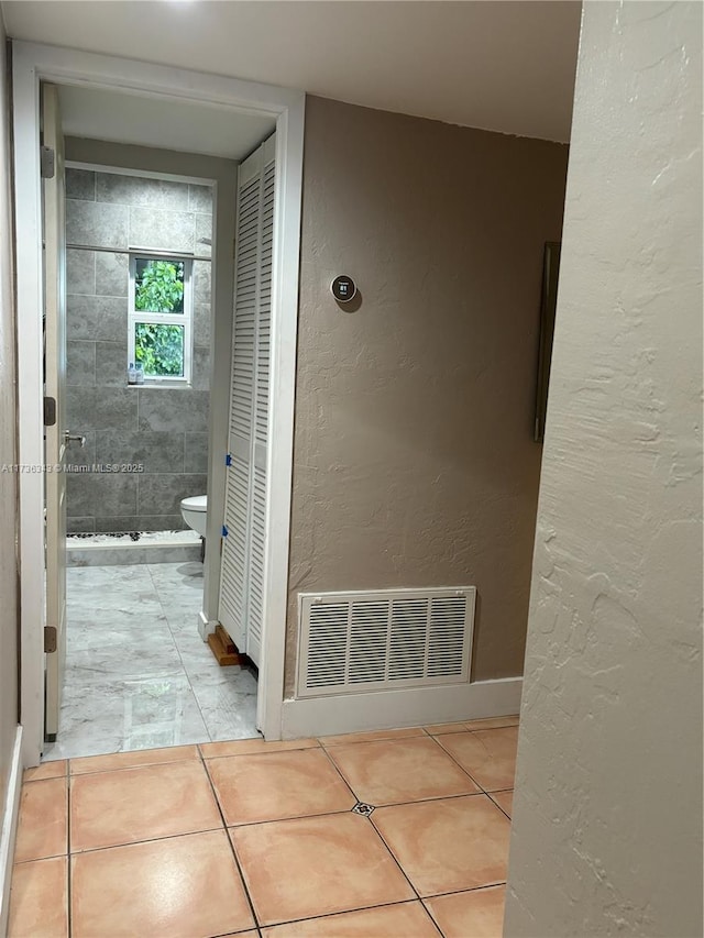 bathroom with toilet and tile patterned flooring