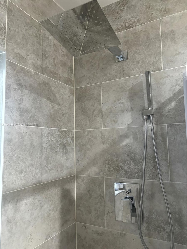 interior details featuring a tile shower