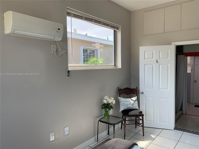 living area featuring an AC wall unit and light tile patterned flooring