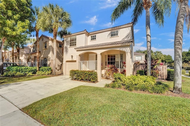 mediterranean / spanish-style home with a garage, covered porch, and a front lawn