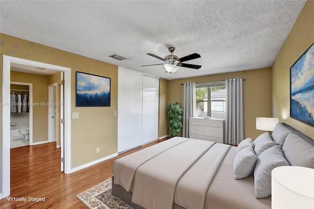 bedroom with a closet, ceiling fan, a textured ceiling, and light hardwood / wood-style flooring