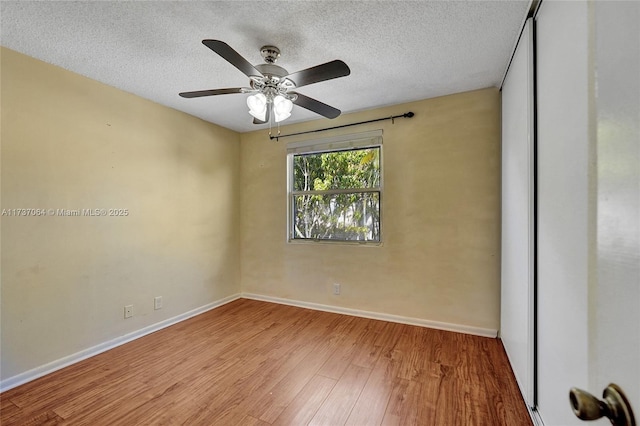 empty room featuring ceiling fan, light hardwood / wood-style floors, and a textured ceiling