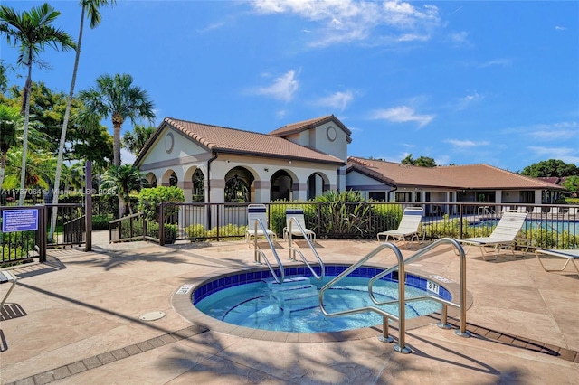 view of pool with a hot tub and a patio