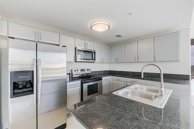 kitchen featuring stainless steel appliances, sink, gray cabinetry, and kitchen peninsula