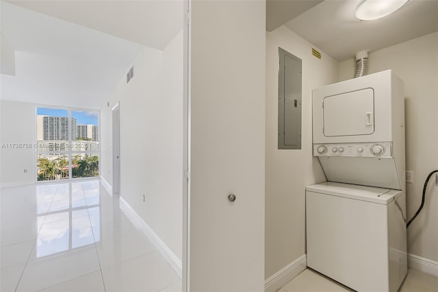 washroom with stacked washer and clothes dryer, electric panel, and light tile patterned floors