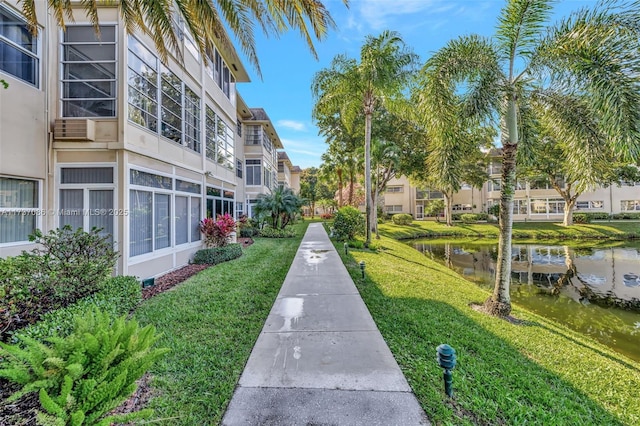 view of home's community featuring a lawn and a water view