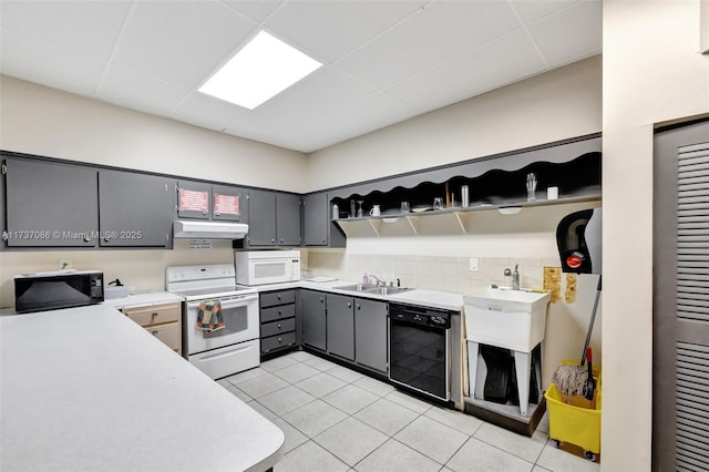 kitchen with light tile patterned flooring, sink, black appliances, gray cabinets, and a drop ceiling