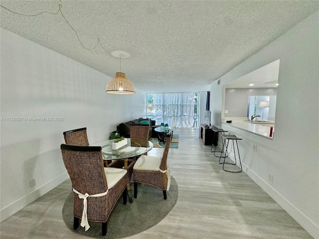 1000 Parkview Dr Unit 202, Hallandale Beach, FL 33009 - dining space featuring a textured ceiling, baseboards, and wood finished floors