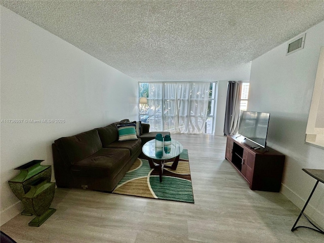 1000 Parkview Dr Unit 202, Hallandale Beach, FL 33009 - living room with a textured ceiling, visible vents, baseboards, light wood-type flooring, and expansive windows
