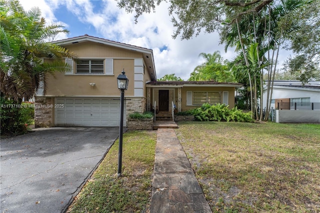 split level home with a garage and a front lawn