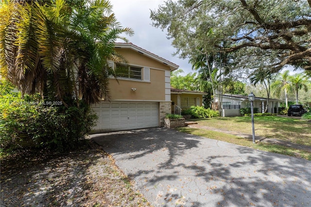 view of side of property featuring a garage and a lawn