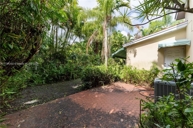 view of yard with central AC and a patio area