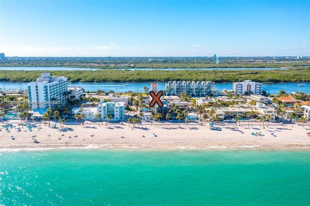 birds eye view of property with a water view and a beach view