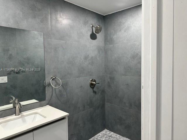 bathroom with vanity and tiled shower