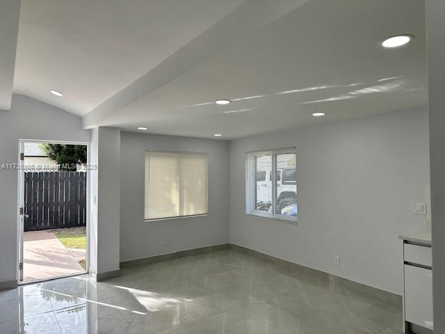 unfurnished room featuring lofted ceiling