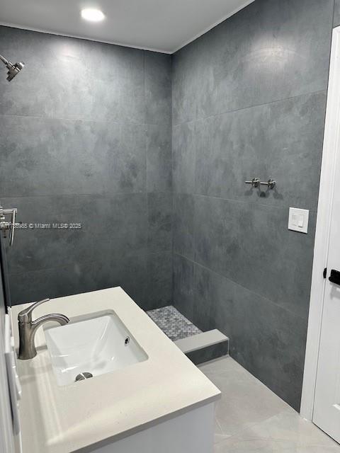 bathroom featuring vanity and tiled shower