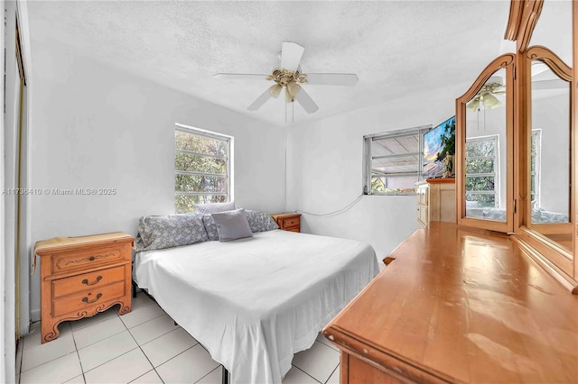 bedroom with ceiling fan, access to outside, and a textured ceiling