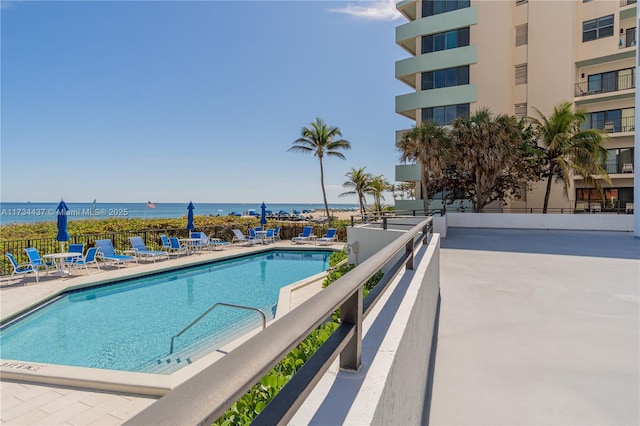 view of pool with a patio and a water view