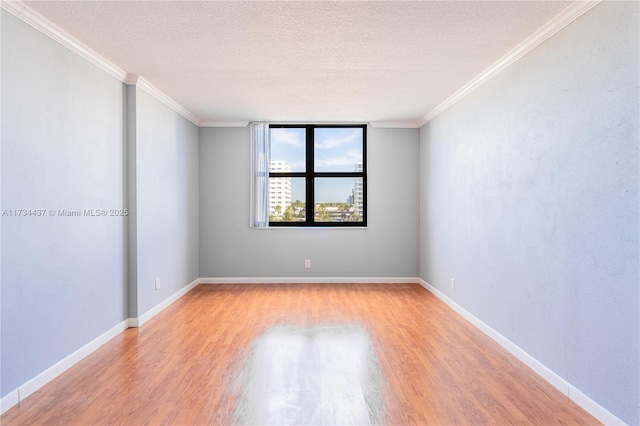 unfurnished room with crown molding, a textured ceiling, and light wood-type flooring