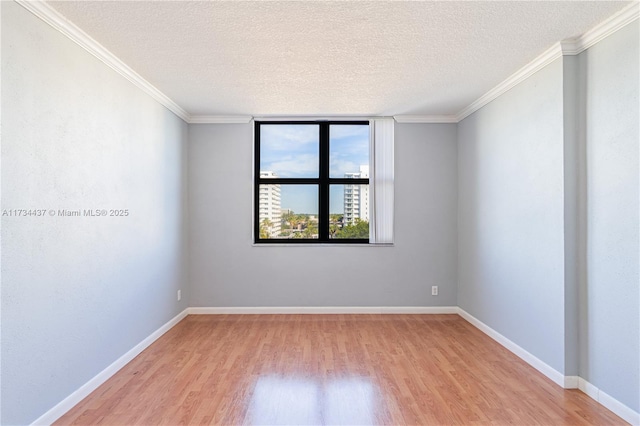 spare room featuring crown molding, a textured ceiling, and light hardwood / wood-style floors