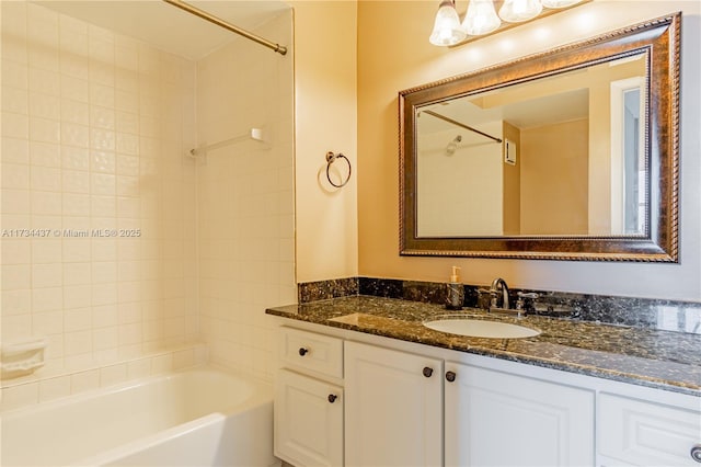 bathroom featuring tiled shower / bath and vanity