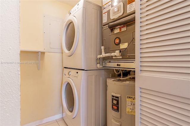 laundry room featuring stacked washing maching and dryer, electric water heater, and light tile patterned flooring