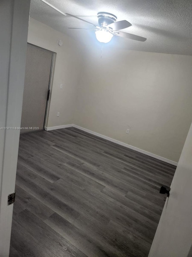 spare room featuring ceiling fan, a textured ceiling, and dark hardwood / wood-style flooring