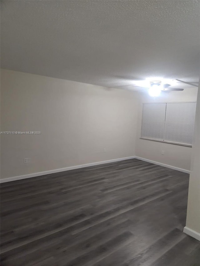 spare room with dark hardwood / wood-style flooring and a textured ceiling