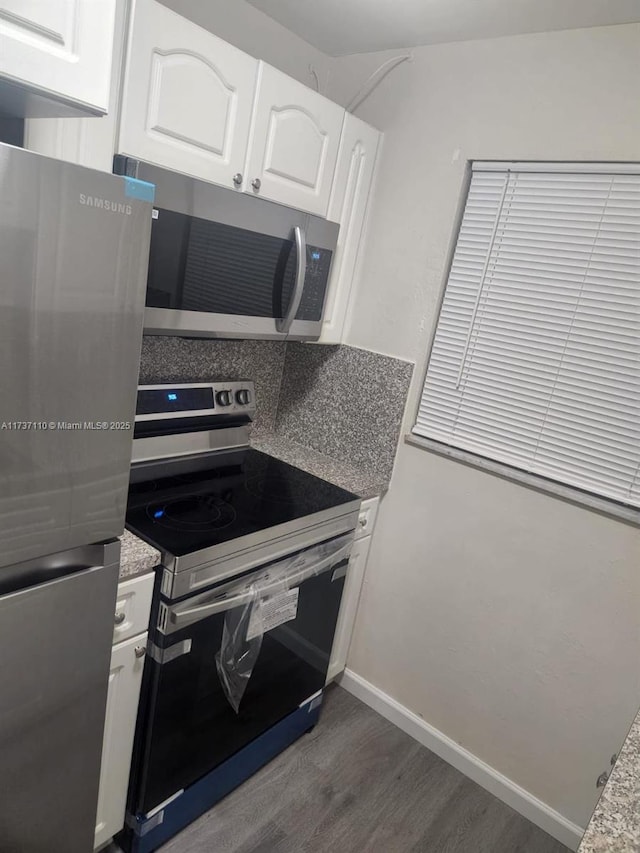 kitchen with white cabinetry, dark wood-type flooring, and appliances with stainless steel finishes