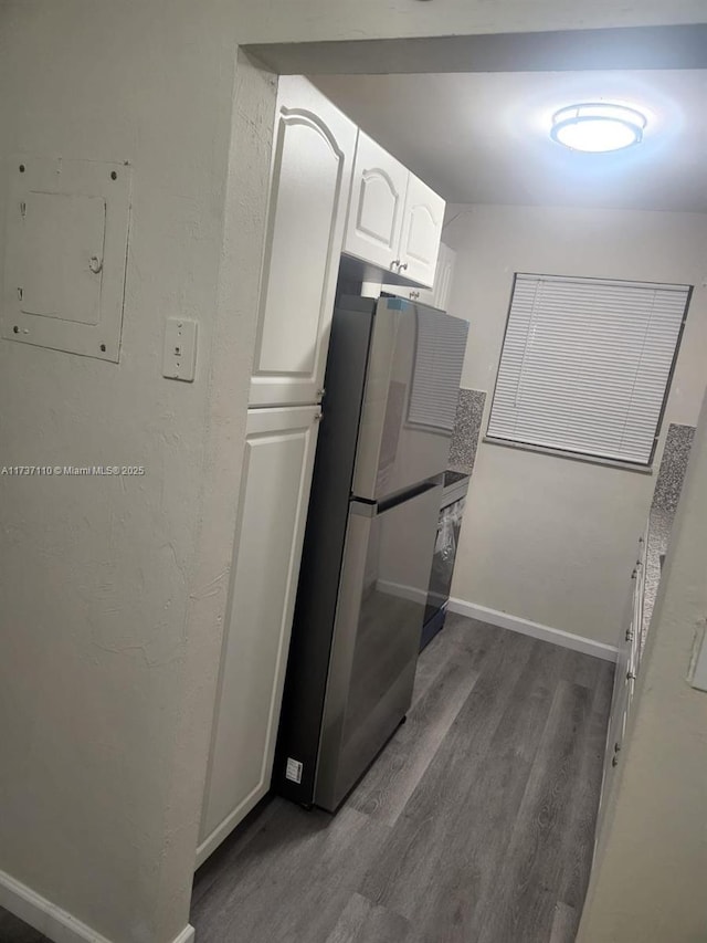 kitchen with dark hardwood / wood-style flooring, white cabinets, stainless steel refrigerator, and electric panel