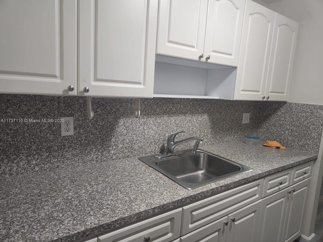 kitchen with tasteful backsplash, sink, and white cabinets